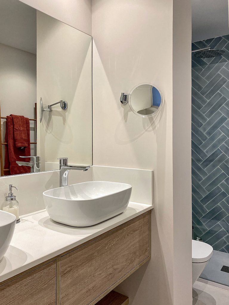 detalle del lavamanos blanco con el espejo