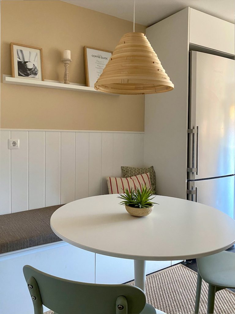 mesa para comer con banco y la nevera a un lado